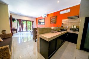 a kitchen with orange walls and a large counter top at Pondok DEWI Villa - LEGIAN - 6 Bedroom Villa - Great Location in Legian