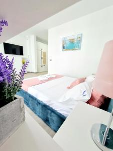 Dormitorio blanco con cama y mesa en Beach Resort Studio Fitness-spa-pool, en Mamaia Nord – Năvodari