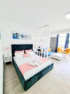 una camera da letto con un grande letto con due asciugamani di Beach Resort Studio Fitness-spa-pool a Mamaia Nord - Năvodari