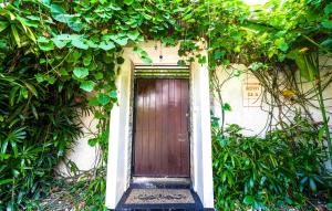 a door in the side of a building with plants at Pondok DEWI Villa - LEGIAN - 6 Bedroom Villa - Great Location in Legian