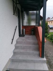 eine Treppe, die zu einem Haus mit einer Veranda führt in der Unterkunft Ferienwohnung Helli in Teisendorf