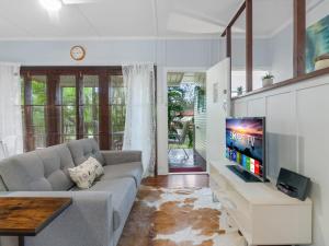 a living room with a couch and a flat screen tv at Great value 3BD house at a convenient location in Brisbane