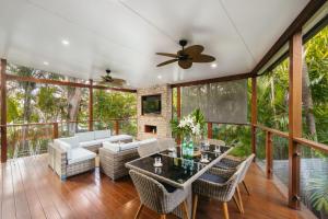 a screened in porch with a table and chairs at Bali Vibes Serene Tropical Oasis 4BD Holiday Home in Brisbane
