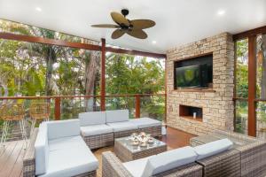 a living room with a fireplace and a tv at Bali Vibes Serene Tropical Oasis 4BD Holiday Home in Brisbane