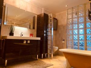 a bathroom with a sink and a tub and a toilet at Sørvågen Villa luxury home with sauna in Sørvågen +48 photos