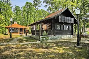 a log cabin in the woods with a porch at Turopoljsko imanje GUSTELNICA in Gustelnica