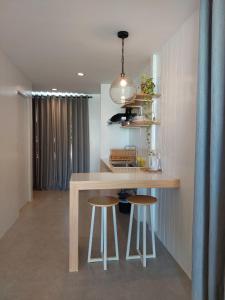 uma cozinha com uma mesa e dois bancos em Sea Green Boutique Rooms em General Luna