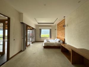 a bedroom with a bed and a large window at Agusta Lake View Bedugul in Pabean Buleleng