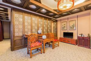 een woonkamer met houten meubels en een flatscreen-tv bij Jianguo Hotspring Hotel in Beijing