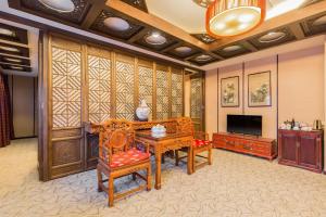 a living room with wooden furniture and a flat screen tv at Jianguo Hotspring Hotel in Beijing