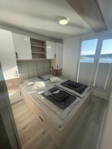 a large bed in a room with a large window at Floating sea house - PULA 1 in Pula
