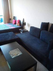 a living room with a blue couch and a table at Studio in Primorsko del Sol in Primorsko
