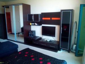 a living room with a tv and a mirror at Studio in Primorsko del Sol in Primorsko