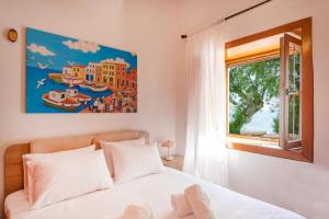 a bedroom with a bed and a window at Seascape Krithoni in Agia Marina