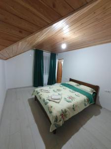 - une chambre avec un grand lit et des rideaux verts dans l'établissement Cabana belvedere (VIS), à Colibiţa