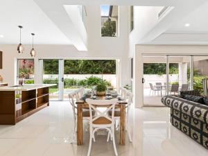 a dining room and living room with a table and chairs at Luxury Hilltop Brand-New 5BD Holiday Home in Brisbane