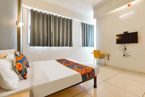 a bedroom with a bed and a television in it at Via Kaviya - Bopal in Ahmedabad +17 photos