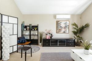 a living room with a black cabinet and a table at Spacious newly redecorated 5BD Family Home in Brisbane