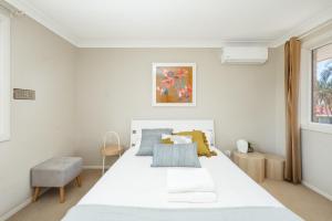 a bedroom with a large white bed and a window at Spacious newly redecorated 5BD Family Home in Brisbane
