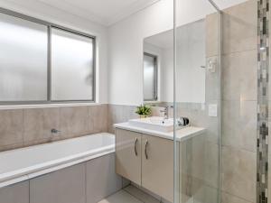 a bathroom with a sink and a tub and a shower at Spacious Newly Furnished 4BD Family Retreat in Doolandella +12 photos