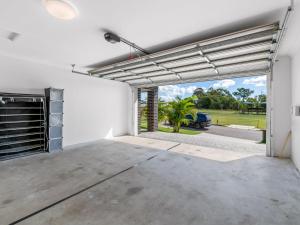 a garage with an open door to a driveway at Spacious Newly Furnished 4BD Family Retreat in Doolandella