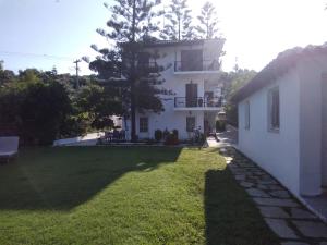 ein großes weißes Gebäude mit einem Rasenplatz in der Unterkunft Villa Ourania in Troulos