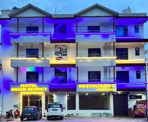 a building with purple and yellow signs on it at Hotel Anjum Regency in Bajaura