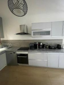 a kitchen with a stove and a microwave at Villa Coco in Trou aux Biches