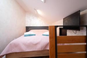 małą sypialnię z łóżkiem i telewizorem w obiekcie BEST4YOU w mieście Subotica