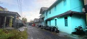 een groep motorfietsen geparkeerd in een straat naast huizen bij SPOT ON 92658 Wisma Parakita Syariah in Makassar