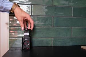 a person holding a remote control in front of a wall at BEST4YOU in Subotica