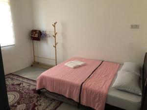 Rasa Sayang Homestay Mersing في ميرسينغ: غرفة نوم صغيرة مع سرير وبطانية وردية