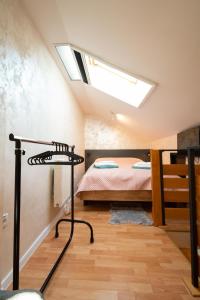 sypialnia na poddaszu z łóżkiem i oknem dachowym w obiekcie BEST4YOU w mieście Subotica