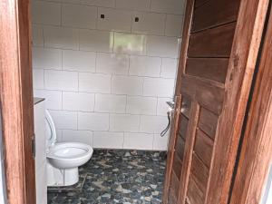 a bathroom with a white toilet and a door at Villa Pondok Dauh Saba in Tabanan
