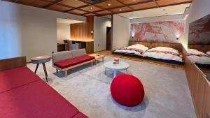 sala de estar con cama y sofá rojo en Houshoutei en Kaga