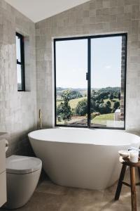 a white bath tub in a bathroom with a large window at The Brooklet in Brooklet