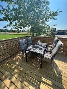una terrazza in legno con tavolo e 2 sedie di Attefallhus Blixtorps Golfbana a Varberg