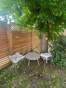 une table et deux chaises assises sous un arbre dans l'établissement La Chambre de Veyrines, à Mérignac