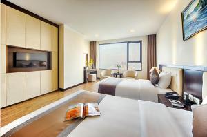 um quarto de hotel com duas camas e uma televisão de ecrã plano em Muong Thanh Grand Cua Lo Hotel em Cửa Lò