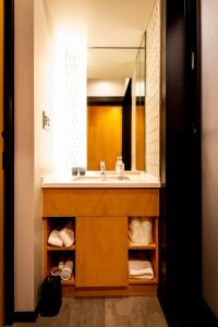 W łazience znajduje się umywalka i lustro. w obiekcie The Villa & Barrel Lounge w mieście Shizuoka
