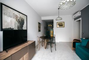 a living room with a flat screen tv and a table at Taormina Argo Apartment by Taormina Holidays in Taormina