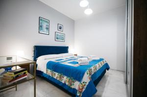 a bedroom with a blue bed and a table at Taormina Argo Apartment by Taormina Holidays in Taormina