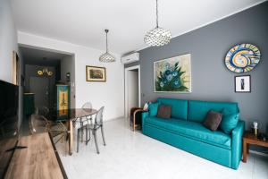 a living room with a blue couch and a table at Taormina Argo Apartment by Taormina Holidays in Taormina