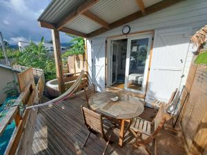 a patio with a table and chairs on a deck at La belle Cabane in Saint-Leu