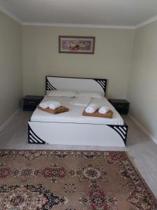 a bedroom with a bed with two towels on it at Гостиница Энглер в Хромтау in Khromtaū +2 photos