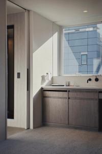 een badkamer met een wastafel en een groot raam bij Hotel Rakuragu in Tokyo