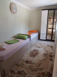 a bedroom with two beds and a rug at Гостиница Энглер в Хромтау in Khromtaū