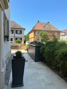 een loopbrug met twee grote planten aan de zijkant van een huis bij Altes Stadthaus mit Garten und Gewölbekeller in Stuttgart