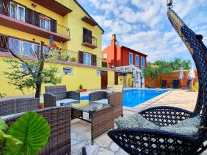 a patio with a table and chairs and a pool at Holiday Home Vlady in Buje