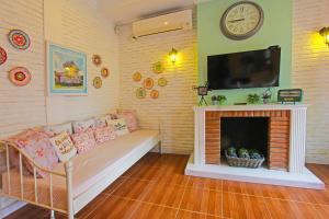 a living room with a couch and a fireplace at Capital O 92559 Sweet Peach House in Senggigi